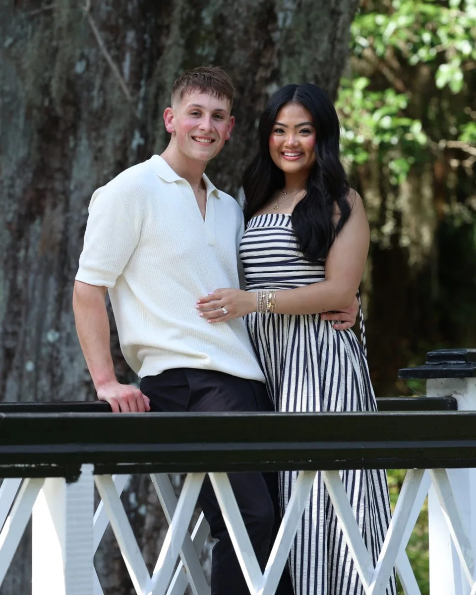 The two of us on a white garden footbridge, smiling, under an old oak hung with Spanish moss.